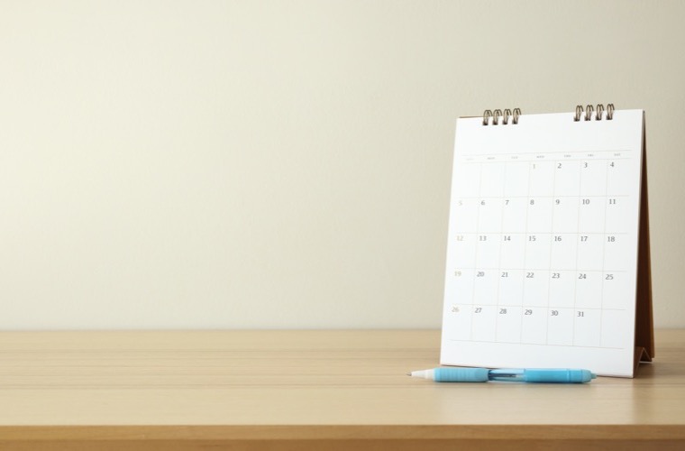 Desk calendar and pens used to coordinate real estate timelines with court dates